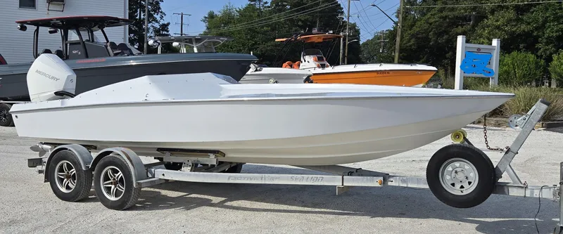 Slide: The Image of 1991 Activator 22 boat on trailer, white hull, parked outdoors. - 10