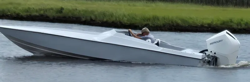 Slide: The Image of Man driving 1991 Activator 22 speedboat with Mercury engine on a calm river. - 2