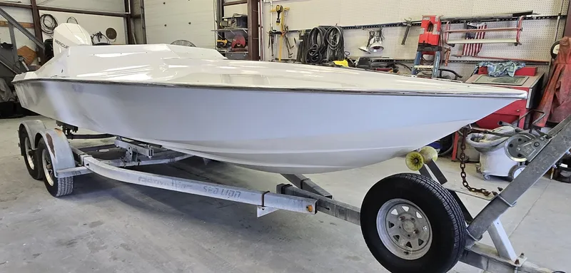 Slide: The Image of White 1991 Activator 22 speedboat on trailer in a garage setting. - 20