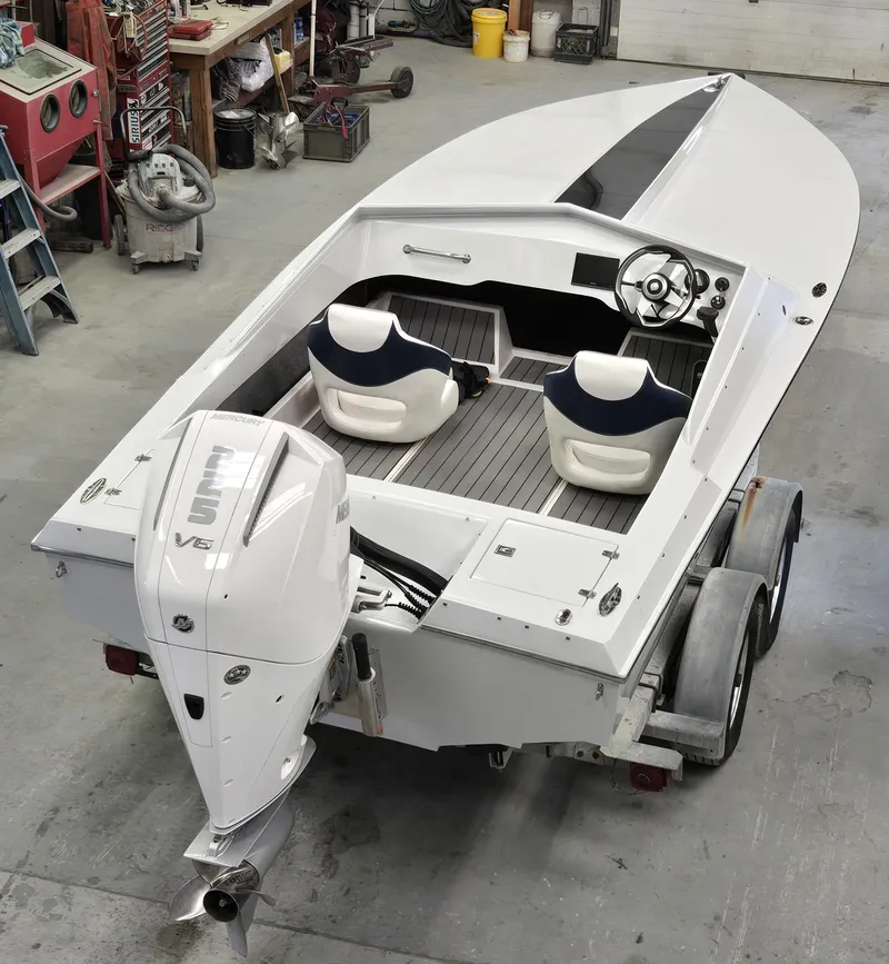 Slide: The Image of 1991 Activator 22 speedboat with dual seats and outboard motor in a workshop setting. - 3