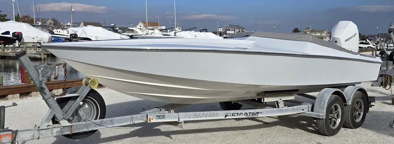 Slide: The Image of 1991 Activator 22 boat on trailer, docked at marina with other boats in background. - 5