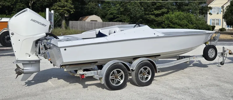 Slide: The Image of 1991 Activator 22 boat with Mercury engine on a dual-axle trailer, parked outdoors. - 9