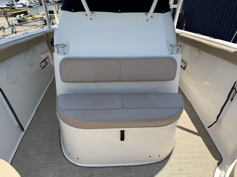 Slide: The Image of 2015 Pursuit S 280 Sport boat seating area with cushioned bench and cup holders. - 11