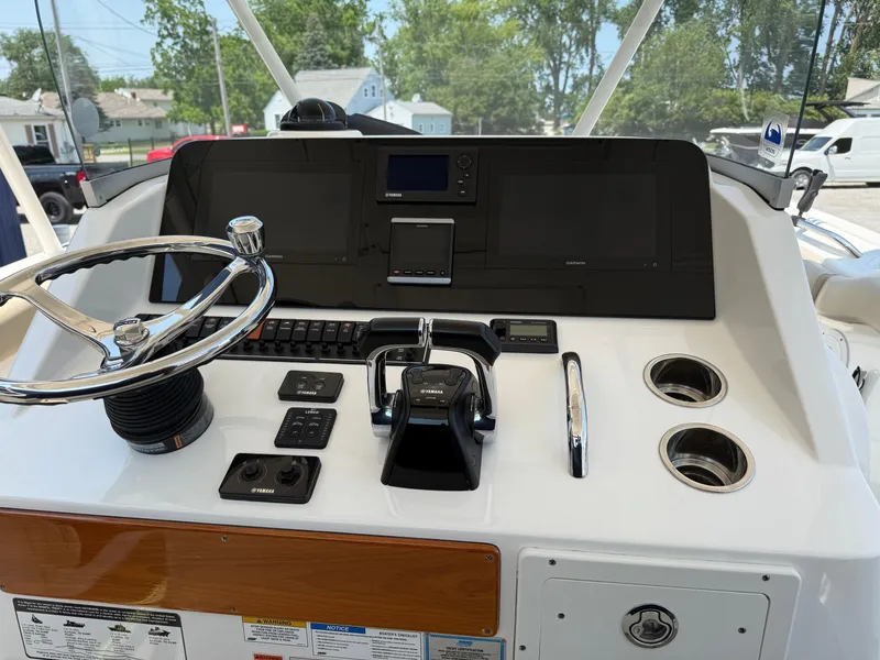 Slide: The Image of 2015 Pursuit S 280 Sport boat dashboard with steering wheel and navigation controls. - 13