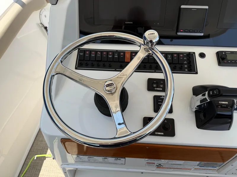 Slide: The Image of Steering wheel and controls of a 2015 Pursuit S 280 Sport boat. - 19