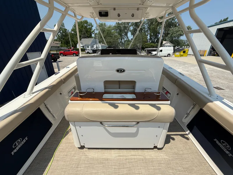 Slide: The Image of 2015 Pursuit S 280 Sport boat interior with seating and console, parked outdoors. - 20