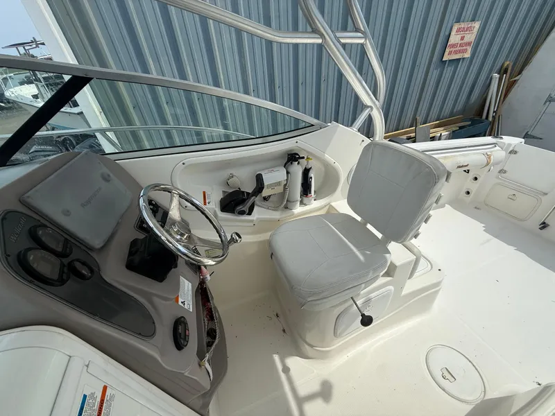 Slide: The Image of 2005 Wellcraft 252 Coastal boat cockpit with steering wheel and seating. - 11