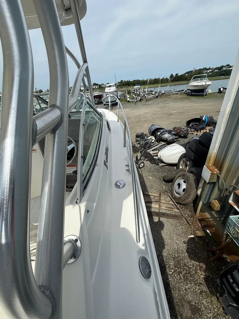 Slide: The Image of 2005 Wellcraft 252 Coastal boat docked near a waterfront with scattered equipment. - 13
