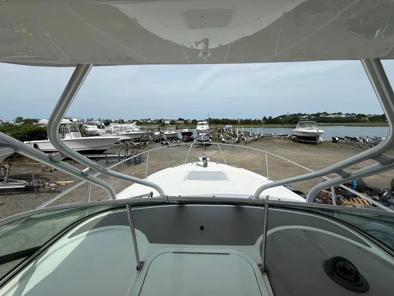 Slide: The Image of 2005 Wellcraft 252 Coastal boat docked, overlooking a marina with multiple boats and a scenic view. - 7
