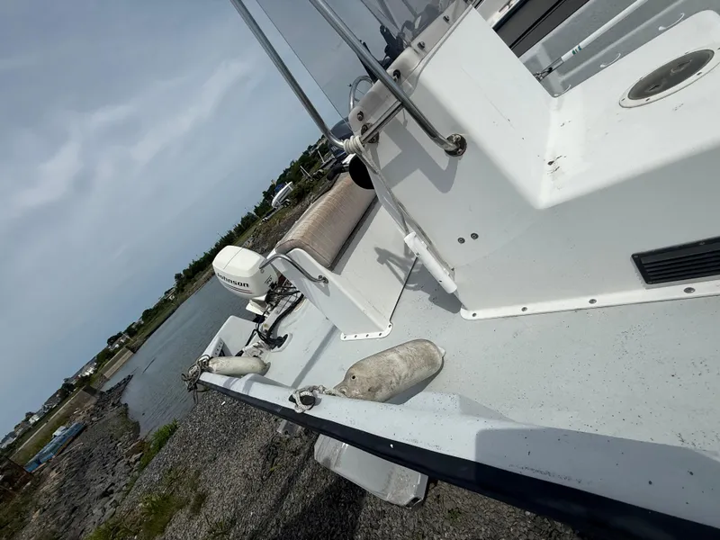 Slide: The Image of 2002 Maritime Skiff 1890 boat on rocky shore with Johnson outboard motor. - 10