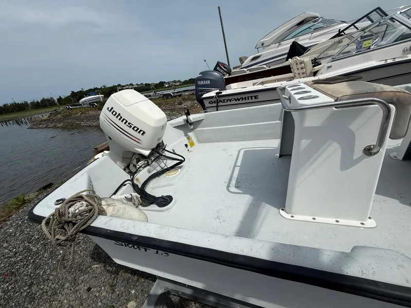 Slide: The Image of Small Maritime Skiff 1890 boat with Johnson outboard motor, docked near water. - 11