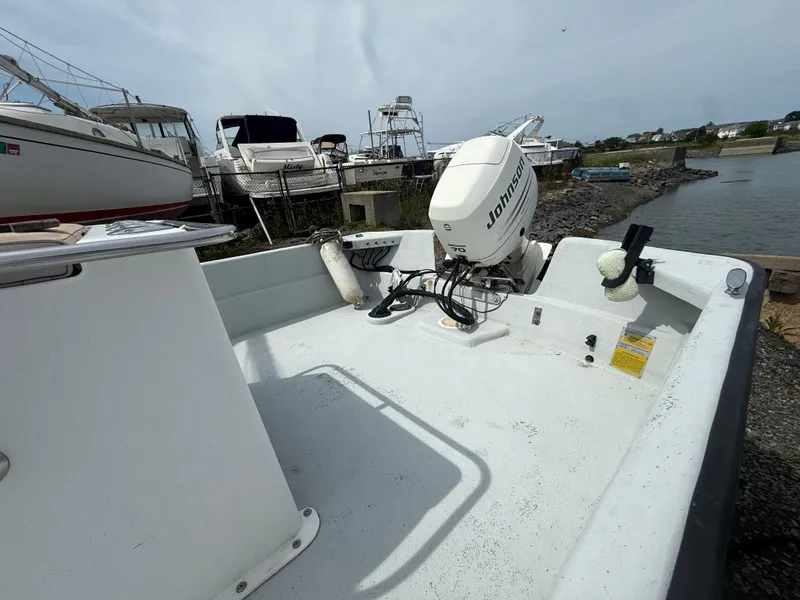 Slide: The Image of 2002 Maritime Skiff 1890 with Johnson outboard motor, docked near other boats. - 5