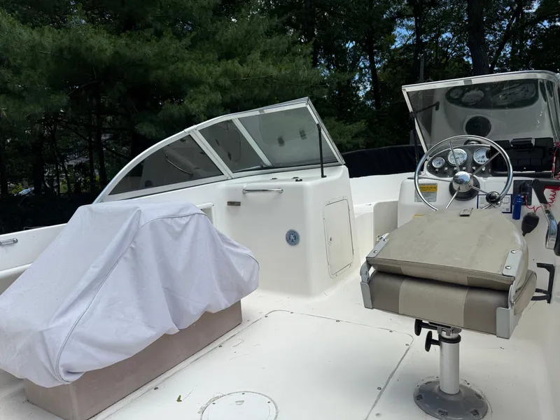 Slide: The Image of 2005 Sea Hunt Escape 200 boat interior with steering wheel and covered seating. - 11