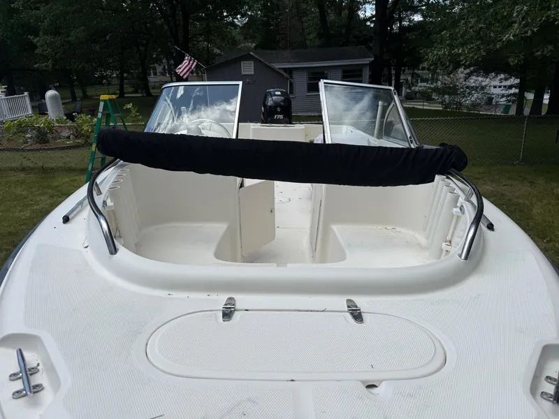 Slide: The Image of 2005 Sea Hunt Escape 200 boat with open deck and windshield, parked in a grassy yard. - 14
