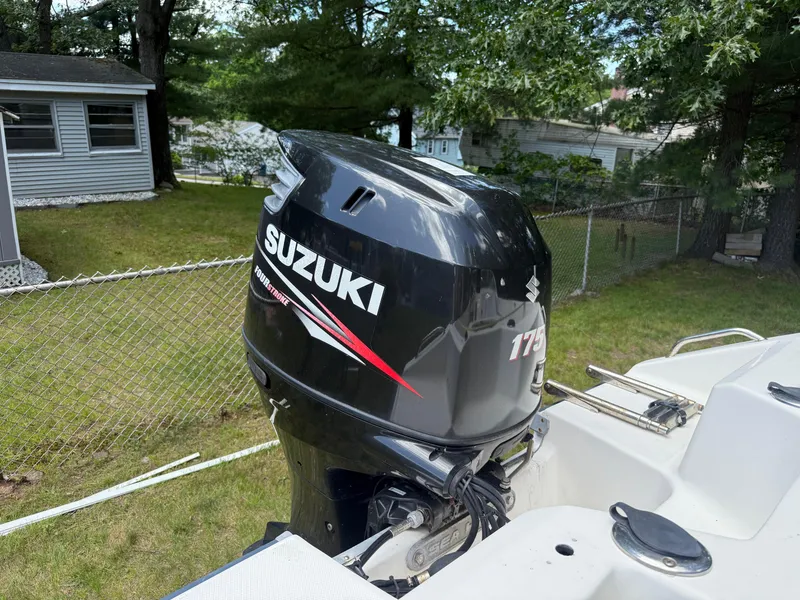 Slide: The Image of 2005 Sea Hunt Escape 200 with Suzuki 175 outboard motor in a backyard setting. - 8