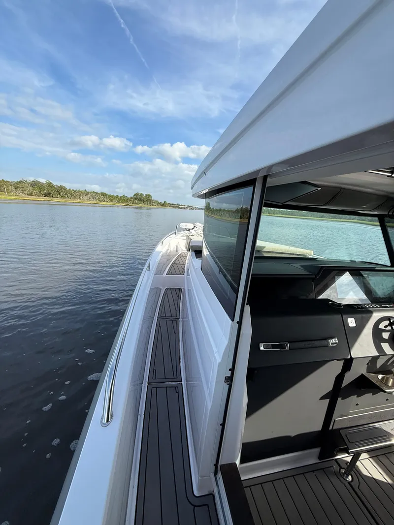 Slide: The Image of 2023 Axopar 37 Cross Cabin boat on calm water, showcasing sleek design and modern features. - 12