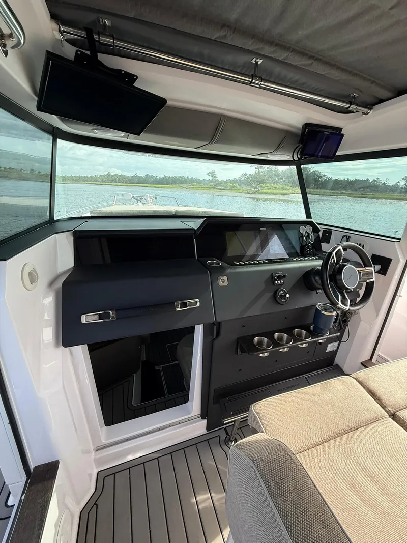 Slide: The Image of Interior of 2023 Axopar 37 Cross Cabin boat with modern dashboard and steering wheel. - 14