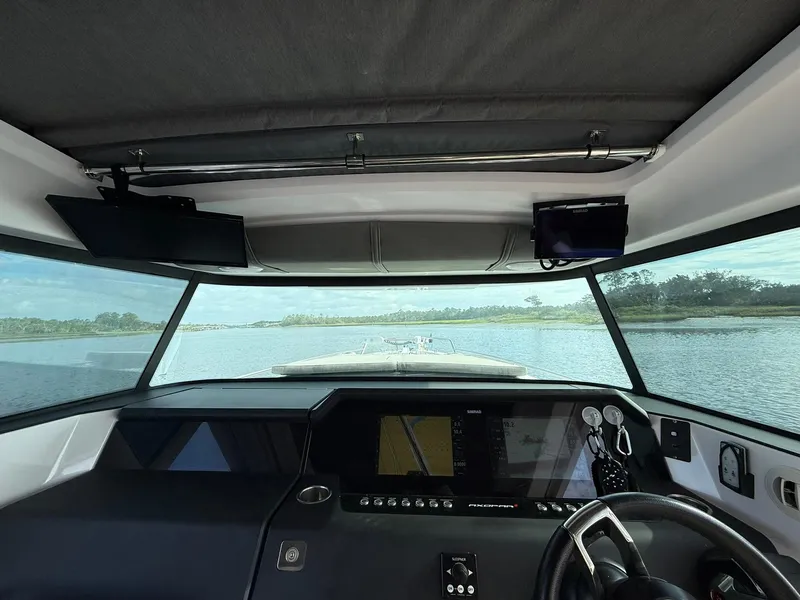 Slide: The Image of Interior view of 2023 Axopar 37 Cross Cabin boat dashboard with scenic waterway. - 16
