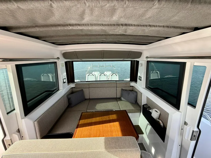 Slide: The Image of Interior of 2023 Axopar 37 Cross Cabin with seating and table, overlooking water. - 17