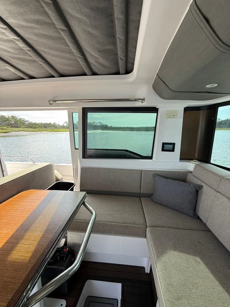Slide: The Image of Interior of 2023 Axopar 37 Cross Cabin with seating and table, overlooking water. - 20
