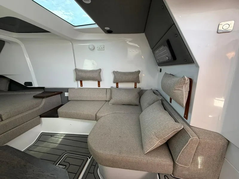 Slide: The Image of 2023 Axopar 37 Cross Cabin interior with modern seating and skylight. - 25