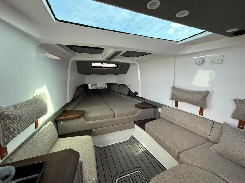 Slide: The Image of 2023 Axopar 37 Cross Cabin interior with modern seating and skylight. - 27