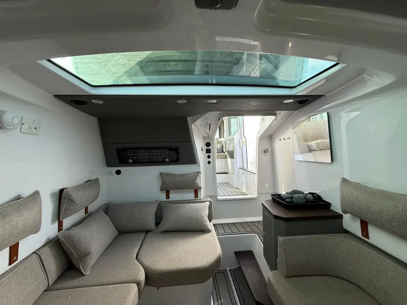 Slide: The Image of Interior of 2023 Axopar 37 Cross Cabin, featuring modern seating and skylight. - 28