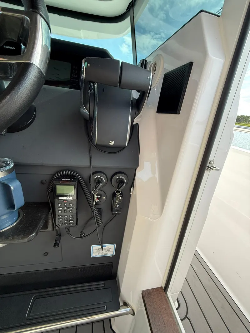 Slide: The Image of Control panel of 2023 Axopar 37 Cross Cabin with steering wheel and communication device. - 30