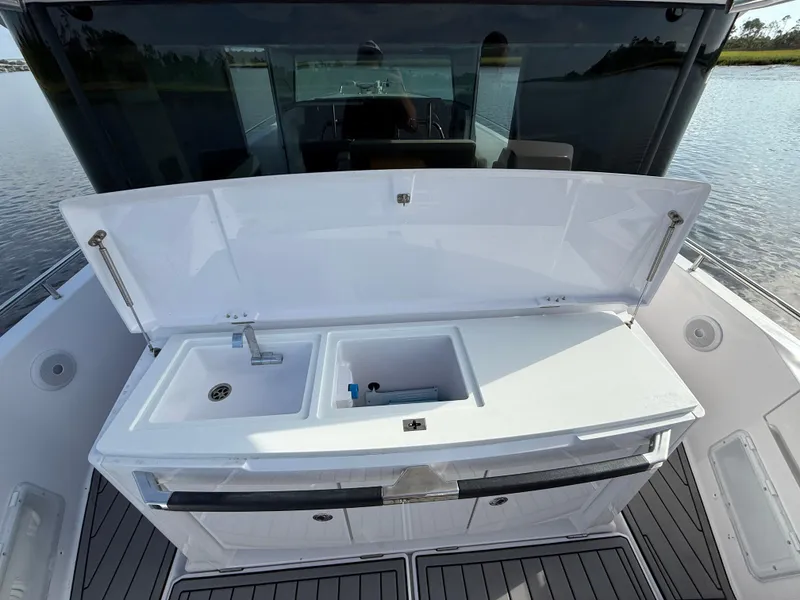 Slide: The Image of 2023 Axopar 37 Cross Cabin boat with open sink and storage area on deck. - 36