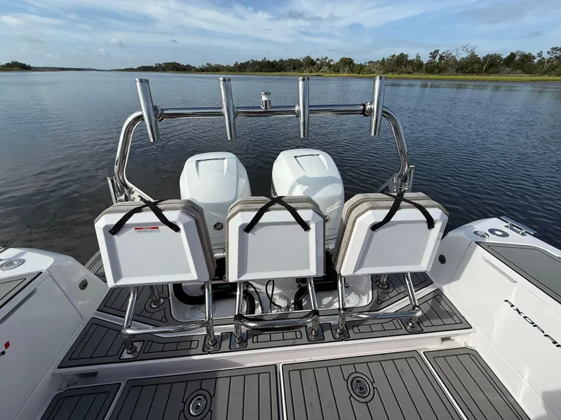 Slide: The Image of 2023 Axopar 37 Cross Cabin boat with dual engines and seating, on calm water. - 37