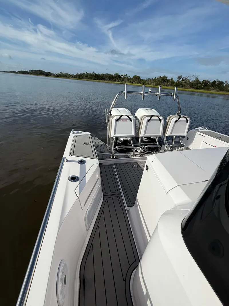 Slide: The Image of 2023 Axopar 37 Cross Cabin boat on calm water, featuring sleek seating and modern design. - 39