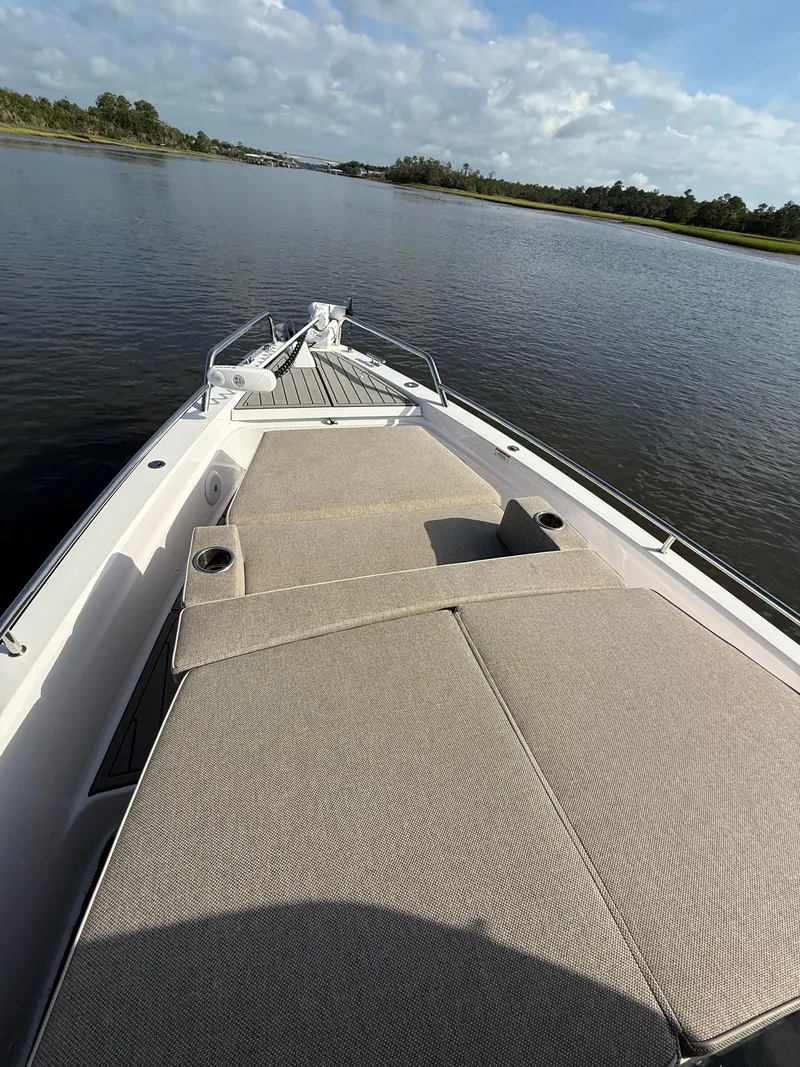 Slide: The Image of 2023 Axopar 37 Cross Cabin boat with spacious deck and scenic water view. - 7