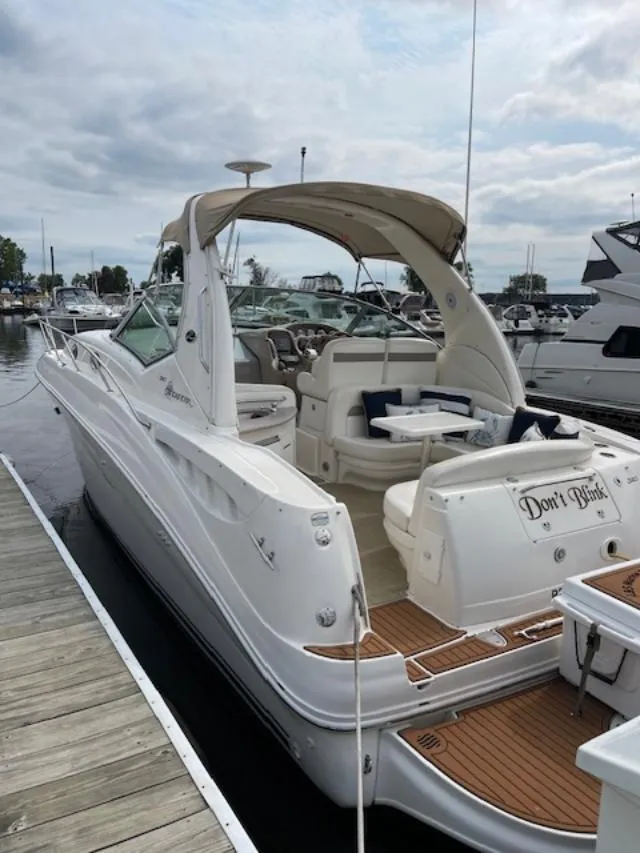 Slide: The Image of 2004 Sea Ray 320 Sundancer docked at marina, featuring spacious seating and elegant design. - 10