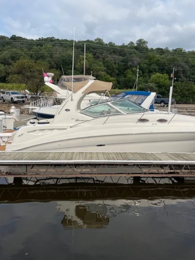 Slide: The Image of 2004 Sea Ray 320 Sundancer docked at a marina with lush green background. - 17