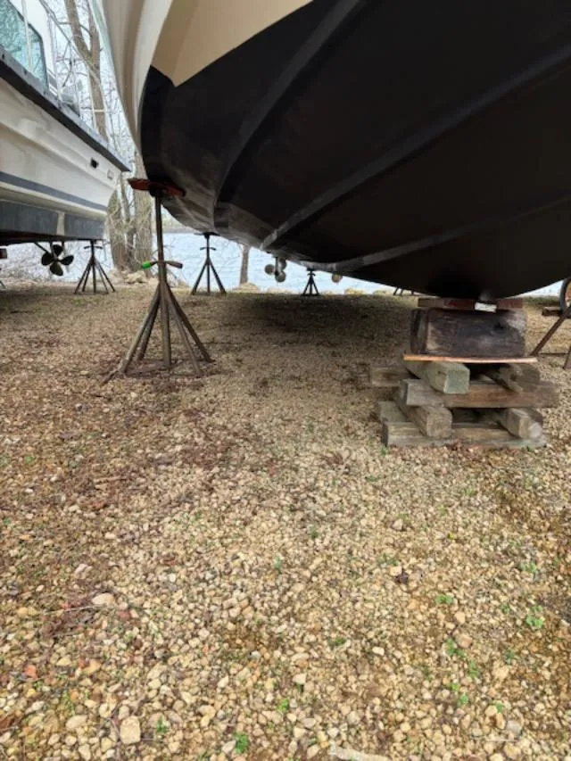 Slide: The Image of 2004 Sea Ray 320 Sundancer boat on stands, gravel ground, side view. - 21