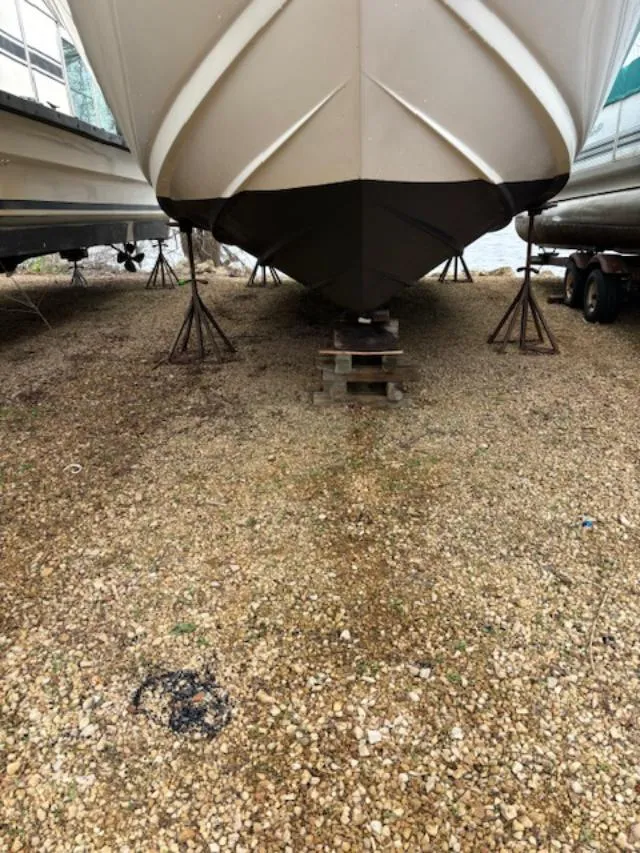 Slide: The Image of 2004 Sea Ray 320 Sundancer boat on stands, gravel ground, front view. - 22