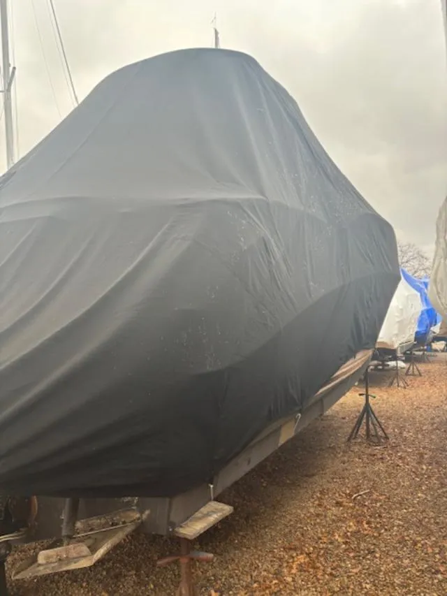 Slide: The Image of Covered 2004 Sea Ray 320 Sundancer boat on stands, outdoors, under cloudy sky. - 23