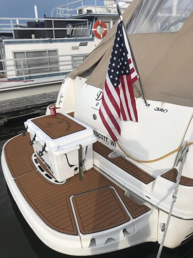 Slide: The Image of 2004 Sea Ray 320 Sundancer boat with American flag at dock. - 24
