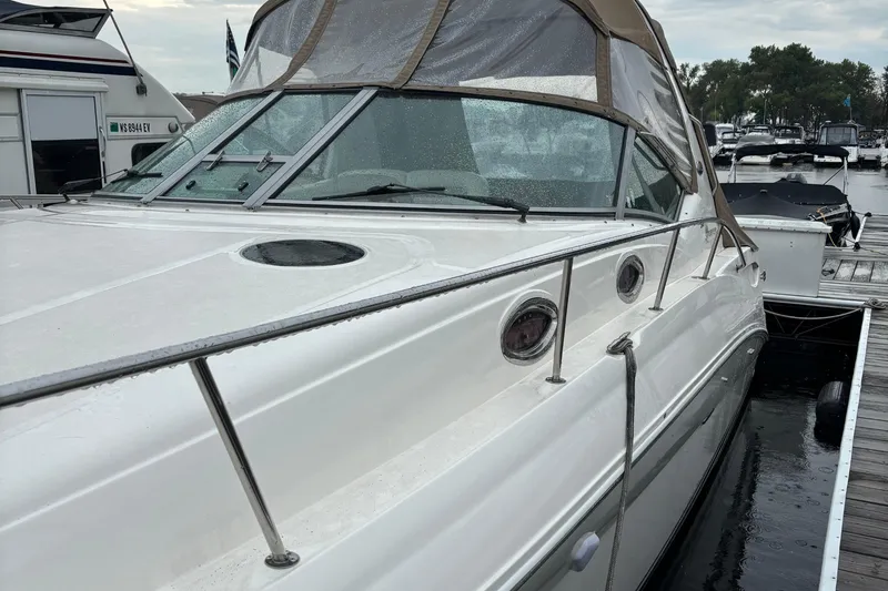 Slide: The Image of 2004 Sea Ray 320 Sundancer docked at marina, featuring sleek design and covered cockpit. - 27