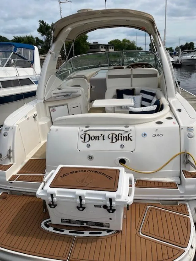 Slide: The Image of 2004 Sea Ray 320 Sundancer boat with "Don't Blink" name, docked with cushioned seating. - 3