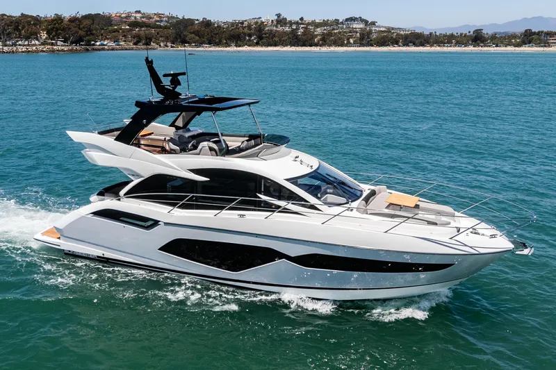 The Image of 2022 Sunseeker Manhattan 55 yacht cruising on blue ocean near coastline. - 0