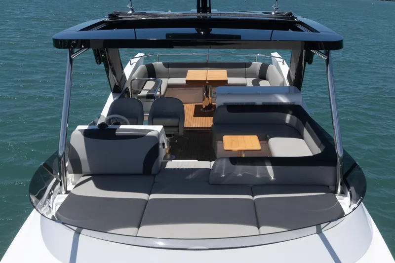 Slide: The Image of 2022 Sunseeker Manhattan 55 yacht with spacious deck and seating, cruising on blue waters. - 13
