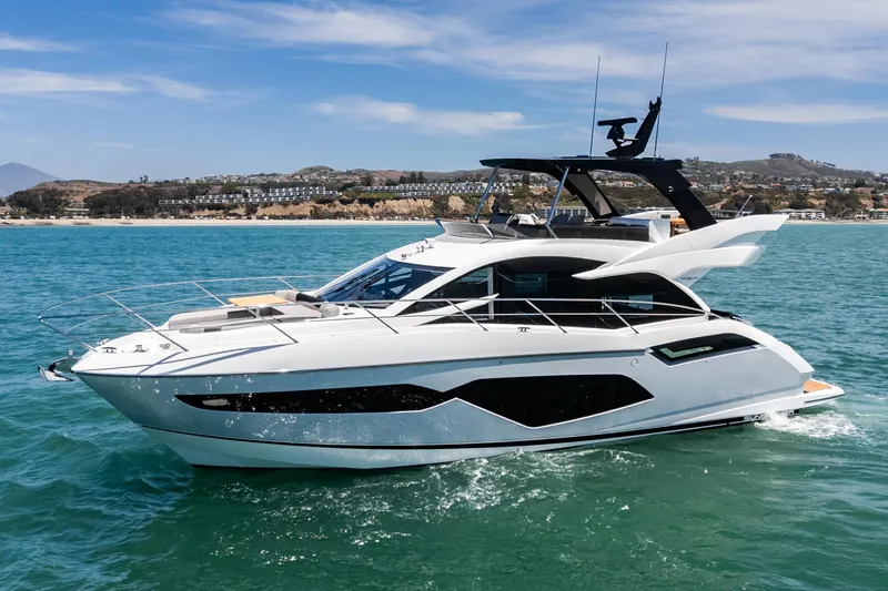 Slide: The Image of 2022 Sunseeker Manhattan 55 yacht cruising on clear blue water. - 2