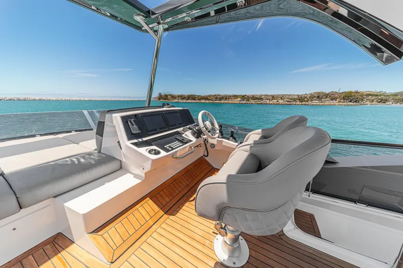 Slide: The Image of Flybridge of 2022 Sunseeker Manhattan 55 yacht with modern helm and ocean view. - 20