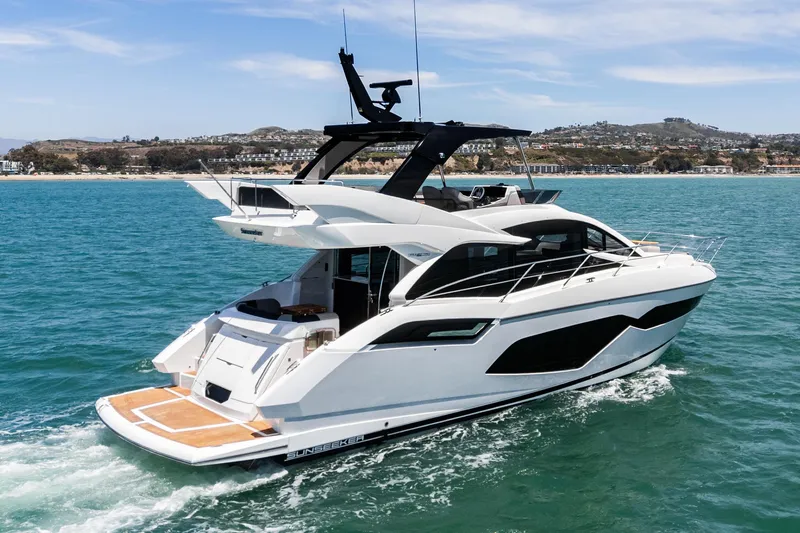 Slide: The Image of 2022 Sunseeker Manhattan 55 yacht cruising on blue ocean near coastline. - 6