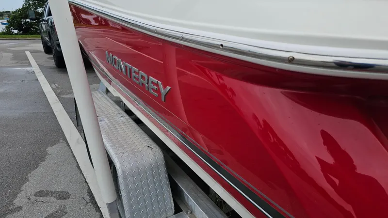 Slide: The Image of 2007 Monterey 214FS Montura boat with red hull on trailer in parking lot. - 11