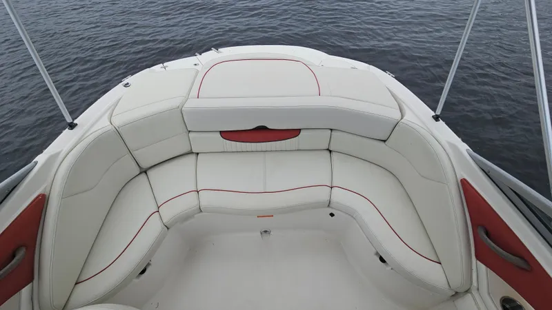 Slide: The Image of 2007 Monterey 214FS Montura boat interior with white seating and red accents on water. - 23