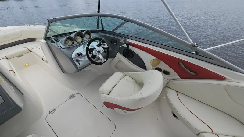 Slide: The Image of 2007 Monterey 214FS Montura boat interior with steering wheel and seating, on calm water. - 24