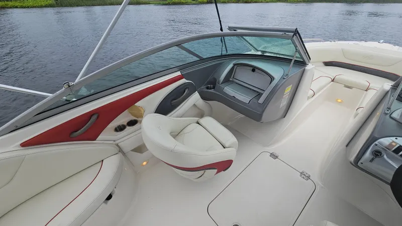 Slide: The Image of 2007 Monterey 214FS Montura boat interior with white seating and red accents on a calm lake. - 25