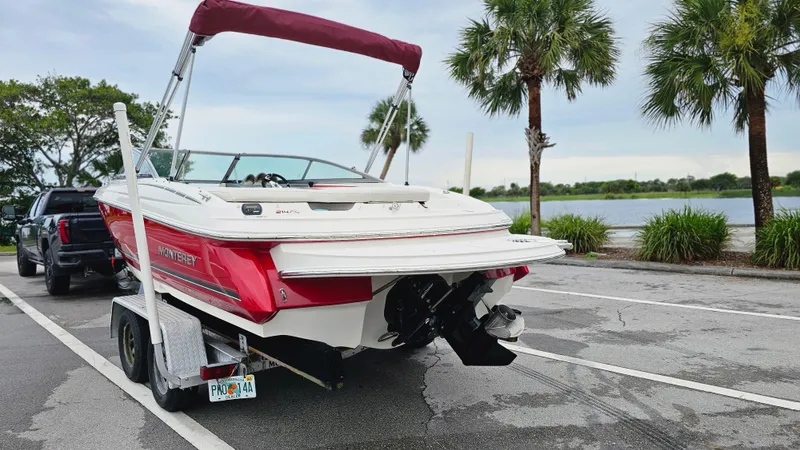 Slide: The Image of 2007 Monterey 214FS Montura boat on trailer near waterfront, surrounded by palm trees. - 3